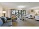 Open floorplan of the living area, with sofa, dining table, two beds, and balcony access at 36750 Us Highway 19 N # 01205, Palm Harbor, FL 34684