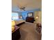Bedroom featuring blue accent wall, carpet flooring, dresser, and bright windows at 38339 Eucalyptus Dr, Zephyrhills, FL 33542