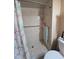 Tiled shower featuring grab bars and a flamingo-themed curtain, ensuring safety and adding a touch of whimsy at 38339 Eucalyptus Dr, Zephyrhills, FL 33542