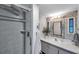 Well-lit bathroom with a modern vanity, stylish mirror, and tiled shower for a spa-like experience at 3834 Kim Dr, Wesley Chapel, FL 33543