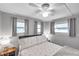 Bedroom with three windows, side tables with lamps, and a ceiling fan at 3834 Kim Dr, Wesley Chapel, FL 33543