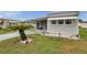 Charming home features a covered parking area, screened porch, and well-maintained landscaping at 3834 Kim Dr, Wesley Chapel, FL 33543