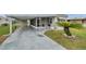Charming home features a covered parking area, screened porch, and well-maintained landscaping at 3834 Kim Dr, Wesley Chapel, FL 33543