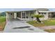 Charming home features a covered parking area, screened porch, and well-maintained landscaping at 3834 Kim Dr, Wesley Chapel, FL 33543