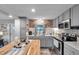 Updated kitchen features grey cabinets, stainless steel appliances, wood backsplash and island at 3834 Kim Dr, Wesley Chapel, FL 33543