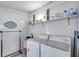 Functional laundry room with washer, dryer, and shelving for organized storage at 3834 Kim Dr, Wesley Chapel, FL 33543