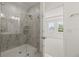 Shower in a modern bathroom with glass door and marble tile; the vanity in the foreground at 408 W Paris St, Tampa, FL 33604