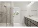 Bright bathroom with walk-in shower featuring marble tile and a dual sink vanity at 408 W Paris St, Tampa, FL 33604