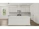 Bright kitchen featuring white cabinets, a kitchen island, stainless steel appliances and wood floors at 408 W Paris St, Tampa, FL 33604