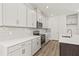 Bright kitchen featuring white cabinets, an island, stainless steel appliances, and wood flooring at 408 W Paris St, Tampa, FL 33604