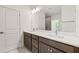 A primary bathroom with a double sink vanity with a stone countertop and gray cabinetry at 410 W Paris St, Tampa, FL 33604