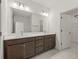 A primary bathroom with a double sink vanity with a stone countertop and gray cabinetry at 410 W Paris St, Tampa, FL 33604
