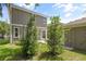 The rear elevation of the house features gray siding and green foliage at 410 W Paris St, Tampa, FL 33604