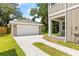 View of a detached garage with a driveway and green lawn at 410 W Paris St, Tampa, FL 33604