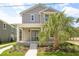 Charming two-story home featuring a welcoming front porch, landscaped yard, and a beautiful palm tree at 410 W Paris St, Tampa, FL 33604