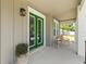 Cozy front porch with green doors and a seating area for relaxation and enjoying the outdoors at 410 W Paris St, Tampa, FL 33604