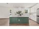 Modern kitchen featuring a large green island, white cabinets, and stainless steel appliances at 410 W Paris St, Tampa, FL 33604