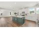 Bright kitchen with green island, white cabinets, stainless steel appliances, and wood flooring at 410 W Paris St, Tampa, FL 33604