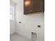 A utility room showcases custom cabinetry, a window, and connections for a washer and dryer at 410 W Paris St, Tampa, FL 33604