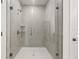 A glass enclosed shower featuring gray tiled walls and a white shower base at 410 W Paris St, Tampa, FL 33604