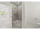 A glass enclosed shower featuring gray tiled walls and a white shower base at 410 W Paris St, Tampa, FL 33604
