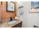 Stylish half-bathroom featuring granite counters, new fixtures, wood paneling, and decor elements at 4851 W Gandy Blvd # B3L35, Tampa, FL 33611