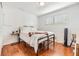 Minimalist bedroom showcases a bed, bedside table, wooden floors, and a sunlit window at 4851 W Gandy Blvd # B3L35, Tampa, FL 33611