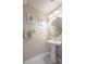 Powder room featuring pedestal sink, a round mirror, decorative prints, and neutral paint color at 4910 Pond Ridge Dr, Riverview, FL 33578