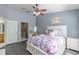 This cozy bedroom offers a large bed with storage, a ceiling fan, and natural light at 4910 Pond Ridge Dr, Riverview, FL 33578
