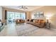 Inviting living room with neutral tones, plush seating, sliding glass doors to screened porch, and ceiling fan at 4910 Pond Ridge Dr, Riverview, FL 33578