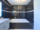 Elegant bathroom featuring black tile, a soaking tub, and a sleek vanity, providing a spa-like experience at 498 Lakewood Dr, Brandon, FL 33510