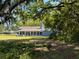Home with enclosed porch, lawn, and mature trees at 498 Lakewood Dr, Brandon, FL 33510