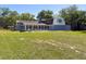 Expansive lawn and home featuring an enclosed porch and patio area with chairs at 498 Lakewood Dr, Brandon, FL 33510