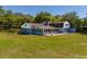 Sprawling property featuring an enclosed porch, patio with chairs, and large lawn with mature trees at 498 Lakewood Dr, Brandon, FL 33510