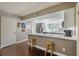 Bright kitchen featuring white cabinets, stainless steel appliances, bar seating, and warm wood floors at 498 Lakewood Dr, Brandon, FL 33510