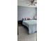 A calming bedroom with a soft blue quilt, and a ceiling fan promoting a restful environment at 522 Mclennan St, Clearwater, FL 33756