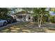 Charming one-story home featuring a manicured front lawn with vibrant palm trees at 522 Mclennan St, Clearwater, FL 33756