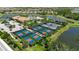 Aerial view of tennis and pickleball courts, surrounded by lush landscaping in the community at 5420 Cicerone St # 103, Sarasota, FL 34238