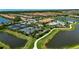 Aerial view of the tennis and pickleball courts and community pool surrounded by lush landscaping and water features at 5420 Cicerone St # 103, Sarasota, FL 34238