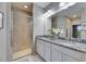 Bathroom featuring granite countertop, double sinks, shower and a large mirror at 5420 Cicerone St # 103, Sarasota, FL 34238