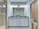 Bathroom featuring a double vanity, large mirror, granite countertop and walk-in shower at 5420 Cicerone St # 103, Sarasota, FL 34238