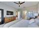 Bedroom featuring carpet floors, large TV, and a view of the ensuite bath and bedroom hallway at 5420 Cicerone St # 103, Sarasota, FL 34238
