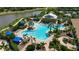 Aerial view of a large community pool featuring palm trees, sun loungers, and beautifully landscaped relaxation areas at 5420 Cicerone St # 103, Sarasota, FL 34238
