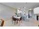 Stylish dining area with modern table and chairs next to a kitchen with white cabinets and granite countertops at 5420 Cicerone St # 103, Sarasota, FL 34238