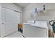 Efficient laundry room with washer, dryer, shelving, and closet at 5420 Cicerone St # 103, Sarasota, FL 34238