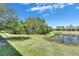 Lush pond scene with verdant foliage and clear skies, creating a peaceful and natural ambiance at 5420 Cicerone St # 103, Sarasota, FL 34238