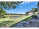 Scenic view of a serene pond surrounded by lush green landscaping and palm trees under a clear blue sky at 5420 Cicerone St # 103, Sarasota, FL 34238