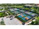 Aerial view of the tennis and pickleball courts surrounded by lush landscaping and a parking area at 5420 Cicerone St # 103, Sarasota, FL 34238