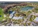 Panoramic aerial view of a community showcasing residences, water features, tennis courts and a golf course at 5473 Blue Heron Ln, Wesley Chapel, FL 33543