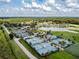 Extensive aerial view highlighting community tennis courts, lakefront views, and sports fields surrounded by lush trees at 5473 Blue Heron Ln, Wesley Chapel, FL 33543